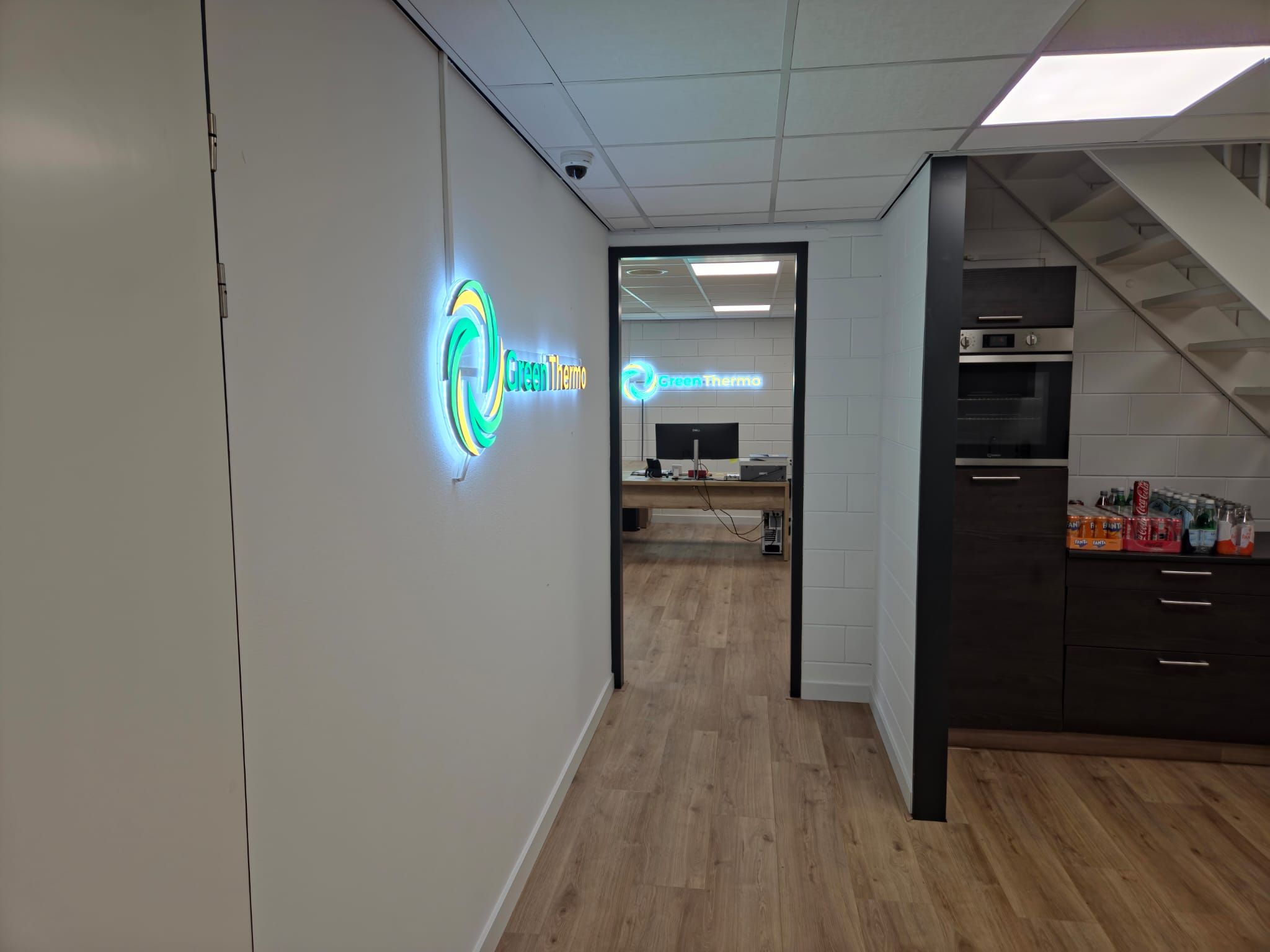 Afgewerkt zakelijk interieur met LED-paneelverlichting, achtergrondverlichte bewegwijzering en elektrische voorzieningen