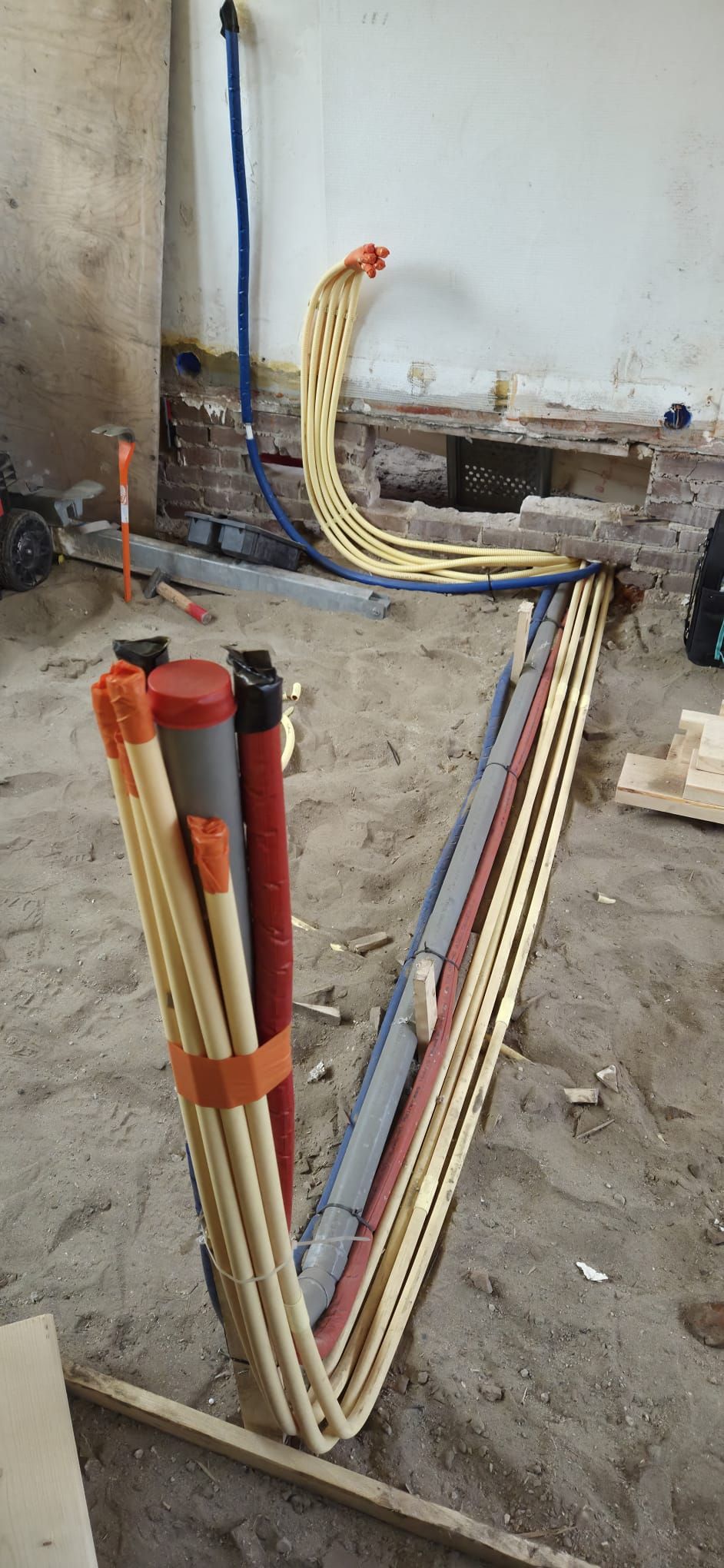Werk in uitvoering: gebundelde elektrische leidingen over de ondervloer tijdens een complete renovatie